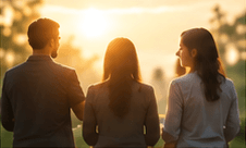 Three colleagues looking out over a landscape at sunrise